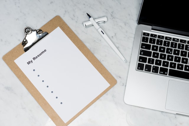 example resume paper resting on a clipboard next to an open laptop