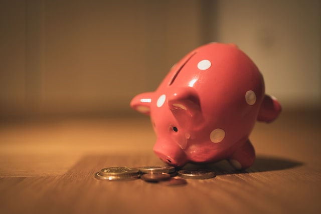 a pink pig coin bank on a brown wooden table
